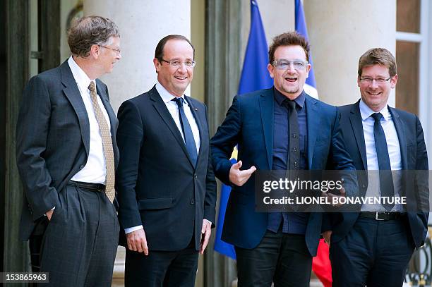 Irish musician and humanitarian activist Bono poses with French President Francois Hollande next to Microsoft co-founder turned global philanthropist...