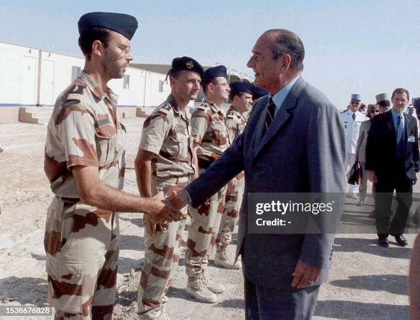 French President Jaques Chirac shakes hands with a French soldiers 13 November 2001 during his visit to AL-Dhafra air base, north of Abu Dhabi, where...