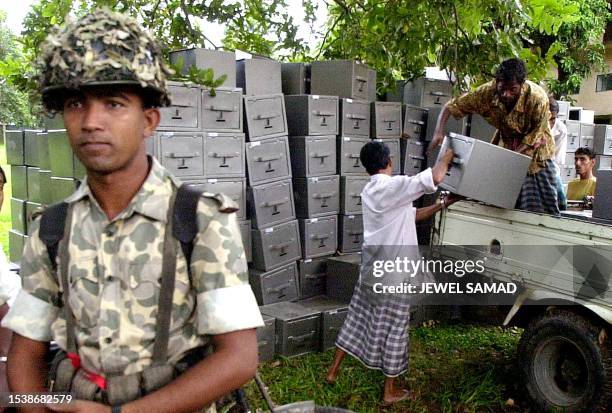 Bangladeshi soldier stands guard as workers loads ballot boxes into a truck destined for various polling centers in Dhaka, 30 September 2001, one day...