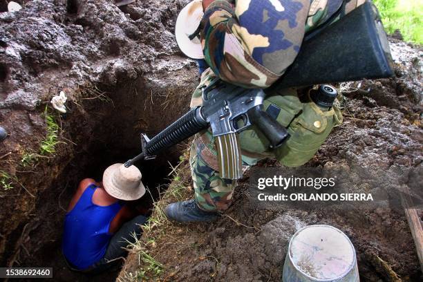 Honduran soldiers stands over a member of the Forensic Medicine Office 30 August at site where the El Aguacate US military base stood, 225kms east of...