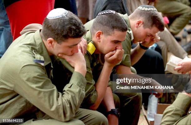 Israeli soldiers grieve during the funeral of 19-year-old Sargeant Itai Dinar at the Rishon Le Zion military cemetery 10 April in Israel. Dinar and...