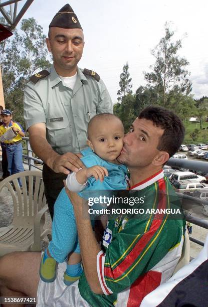 Julio Cesar Baldivieso of Bolivia kisses the daughter of a police officer, 14 July 2001 in Rio Negro, Colombia. Baldivieso is in Colombia for the...
