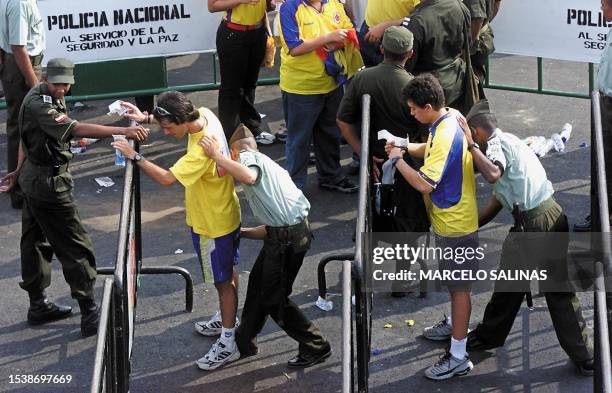 Colombian police inspect soccer fans at one of the entrances of the Roberto Melendez stadium in Barranquilla, Colombia, 14 July 2001, during the Copa...