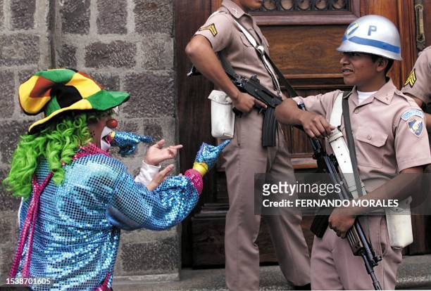 Clown gestures to a gaurd outside the Presidential Home, in the center of Guatemala City, Guatamala, 31 May 2001. Un payaso le hace gestos a un...