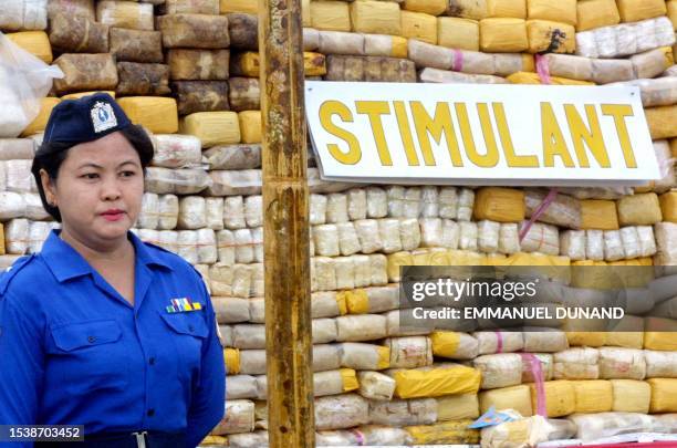 Myanmar soldier stands next to a stockpile of seized methamphetamine pills 12 May 2001 prior to a drug burning ceremony showcased by Myanmar military...