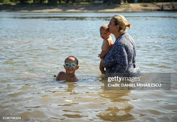 Mother bathes with her sons in a branch of Danube river next to Frecatei village in the eastern Dobrogea region, some 55 kilometers south of Braila,...