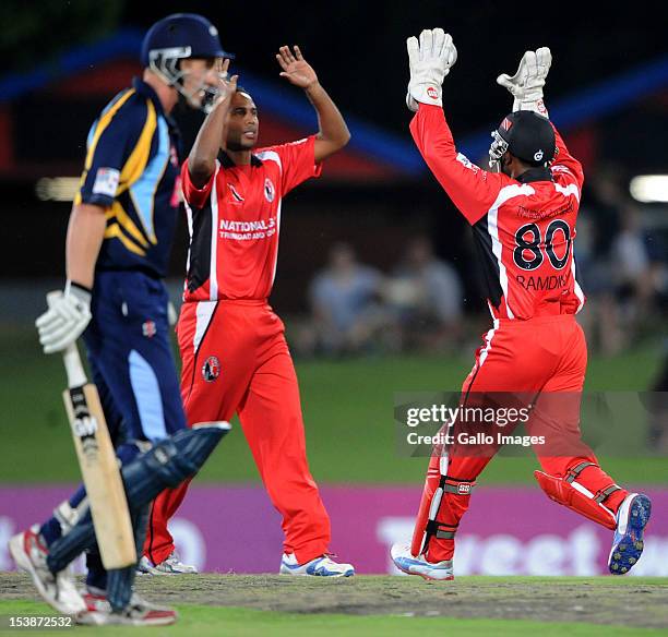 Rayad Emrit of Trinidad & Tobago celebrates the wicket of Andrew Gale with Denesh Ramdin during the Karbonn Smart CLT20 pre-tournament Qualifying...