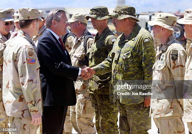 United States Secretary of Defense Donald Rumsfeld is greeted by Lt. Col. Pat Stogran and RSM C.W.O. Comeau of the 3 Princess Patricia's Canadian...