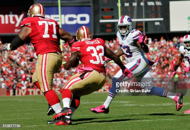 Running back Kendall Hunter of the San Francisco 49ers runs the ball out of the endzone as defensive end Mark Anderson of the Buffalo Bills pursues...