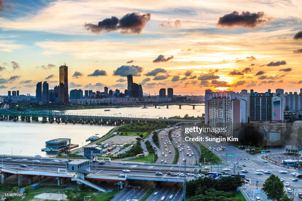 Cityscape with river and bridge by sunset