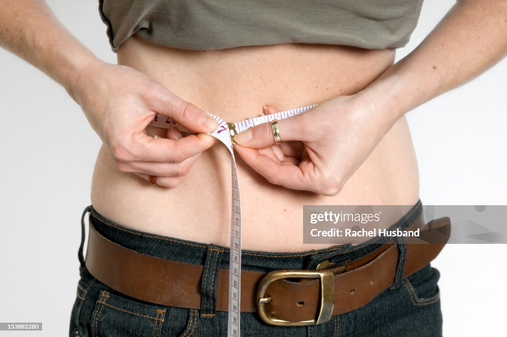 A woman measuring her waist