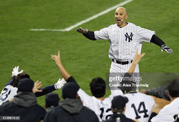 Raul Ibanez of the New York Yankees reaches his teammates at home place after hitting a walk off home run in the bottom of the twelfth inning against...