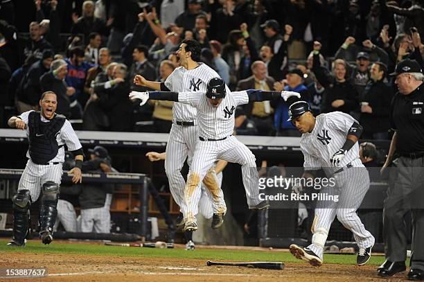 Members of the New York Yankees react to Raul Ibanez of the New York Yankees hitting a game winning, walk off home run in the bottom of the twelfth...
