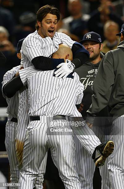 Raul Ibanez of the New York Yankees celebrates a walk off home run in the bottom of the twelfth inning with teammate Nick Swisher after defeating the...