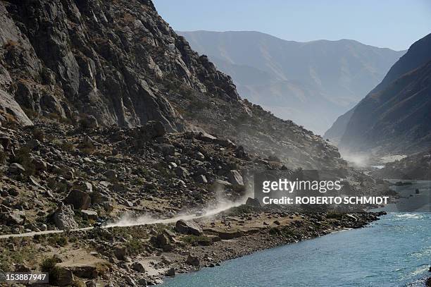 This photo taken on October 6, 2012 shows two pick-up trucks making their way west on the main road connecting the capital of Faizabad in the...