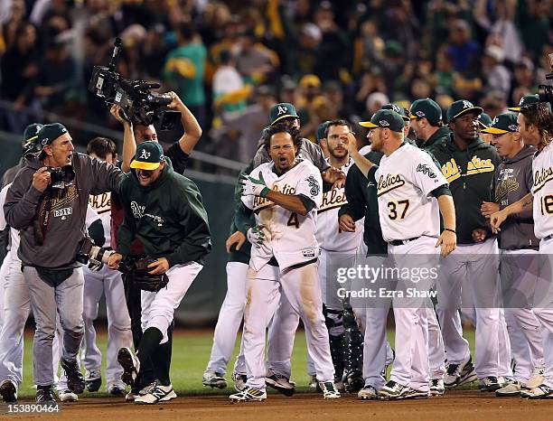 Coco Crisp of the Oakland Athletics is congratulated by teammates after he hit a game-winning single to beat the Detroit Tigers in the ninth inning...