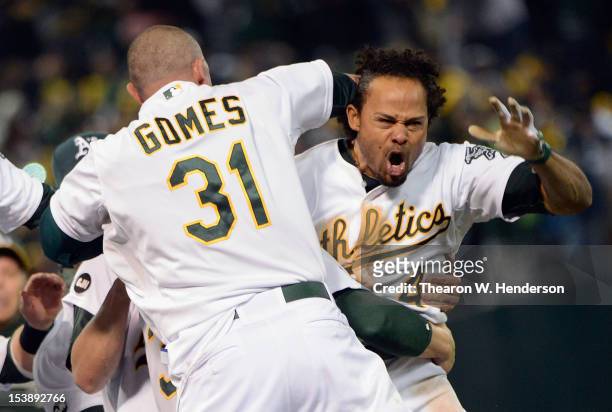 Coco Crisp of the Oakland Athletics celebrates with the team after hitting a walkoff single against the Detroit Tigers during Game Four of the...