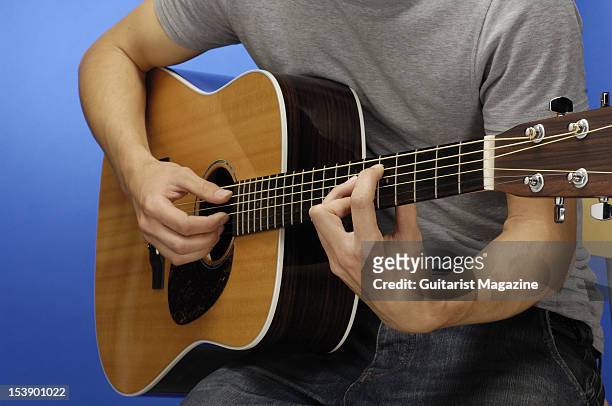 Close-up shot of a man playing an acoustic guitar during a studio shoot for Guitarist Magazine/Future via Getty Images, June 10, 2010.