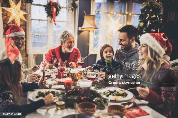 happy extended family having new year's lunch at dining table. - christmas togetherness stock pictures, royalty-free photos & images