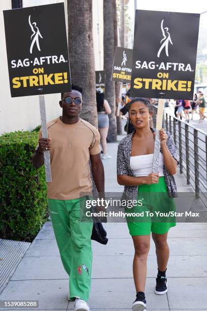 Olly Sholotan and Jazlyn Martin walk the picket line in support of the SAG-AFTRA and WGA strike on July 17, 2023 in Los Angeles, California.