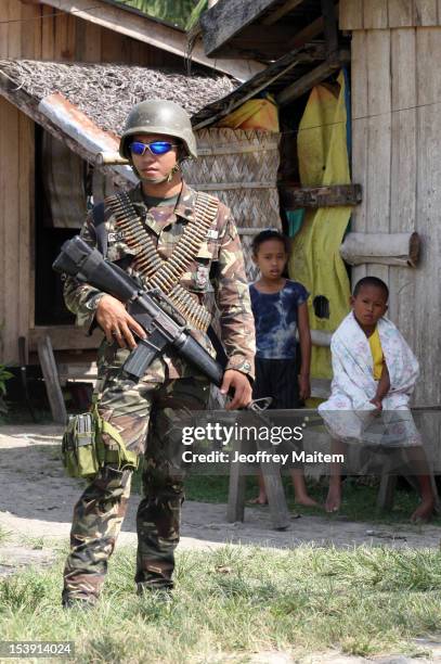 Filipino soldier secures a village along the highway not far from an area where a breakaway faction of the Moro Islamic Liberation Front are armed...