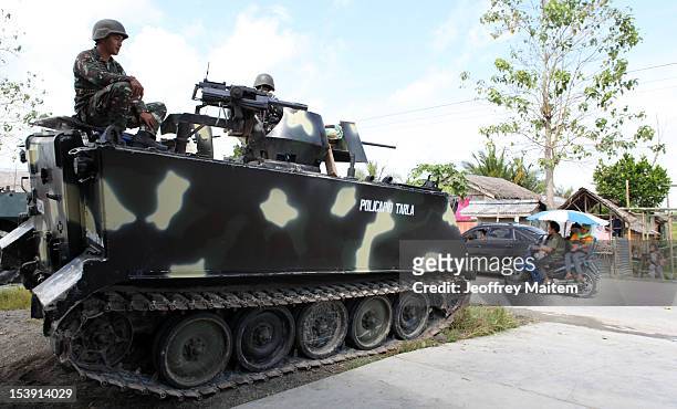 Filipino soldiers secure a village along the highway not far from an area where a breakaway faction of the Moro Islamic Liberation Front are armed...
