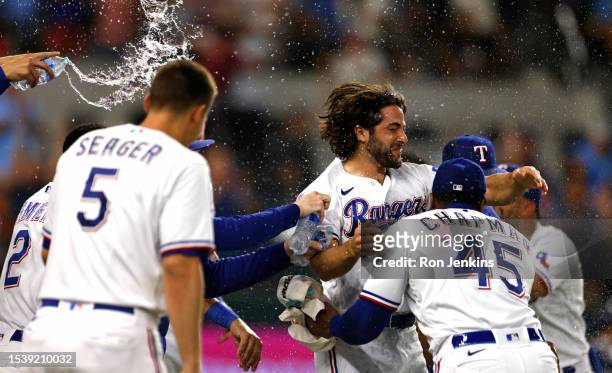 Josh Smith of the Texas Rangers celebrates with teammates after scoring the winning run on a wild pitch against the Tampa Bay Rays during the ninth...