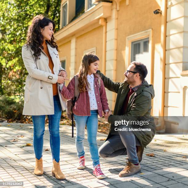 娘を学校に連れて行く母と父親 - school yard ストックフォトと画像