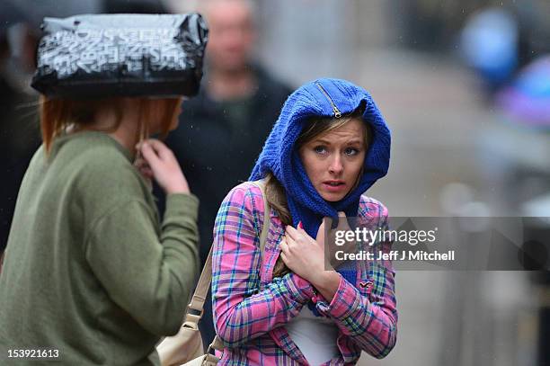 Members of the public shelter from the rain on Buchanan Street on October 11, 2012 in Glasgow, Scotland. Many parts of Scotland have been warned by...
