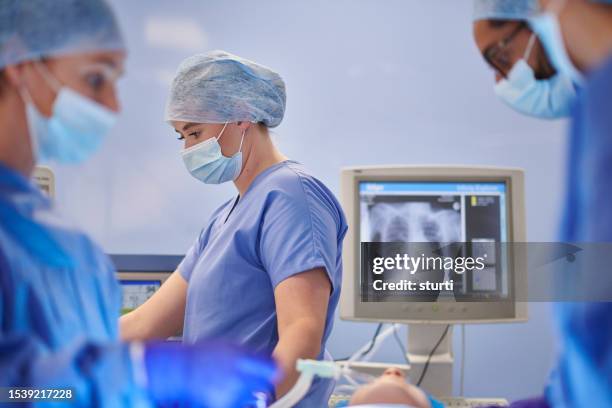 female anesthesiologist in surgery - anesthesioloog stockfoto's en -beelden
