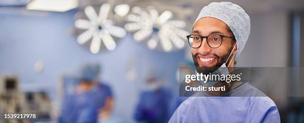 smiling operating theatre nurse - blue surgical mask stock pictures, royalty-free photos & images