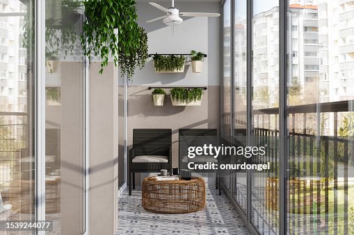Varanda fechada moderna com cadeiras de vime, mesa de centro e plantas creeper Varanda fechada moderna com cadeiras de vime, mesa de centro e plantas creeper