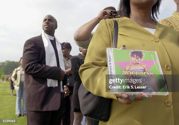 Terry Holmes of Florida holds a CD by Lisa "Left Eye" Lopes while waiting in line to attend the public funeral of the TLC singer at the New Birth...
