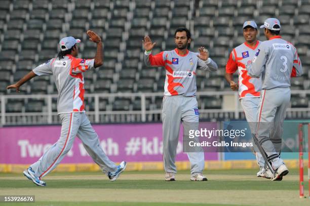 Shoaib Malik of Sialkot Stallions celebrates the wicket of Michael Carberry of Hampshire with his teammates during the Karbonn Smart CLT20...