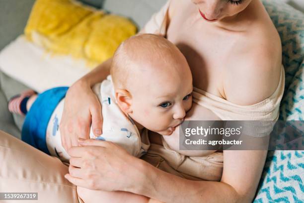 mother breastfeeding her baby boy - dia bildbanksfoton och bilder