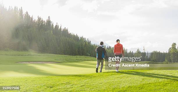 golf couple walk onto green at sunrise, mtns - campo golf fotografías e imágenes de stock