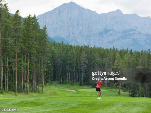 golfer prepares to drive ball down fairway, mtns - women golf stock pictures, royalty-free photos & images