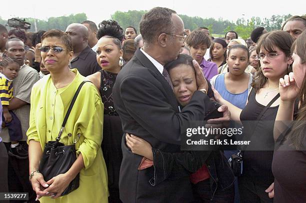 Distraught fan is comforted by a church deacon waiting in line to attend the public funeral of singer Lisa "Left Eye" Lopes at the New Birth...