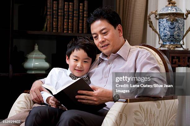 grandpa and grandson reading book in study - chinese family stock pictures, royalty-free photos & images