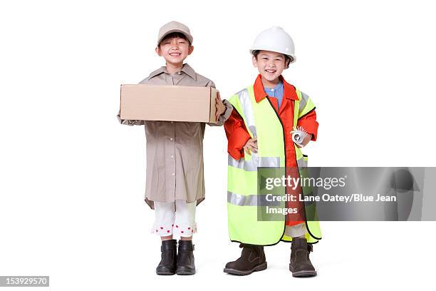 boy and girl dressing up like delivery person and engineer - kids costume engineer stock-fotos und bilder