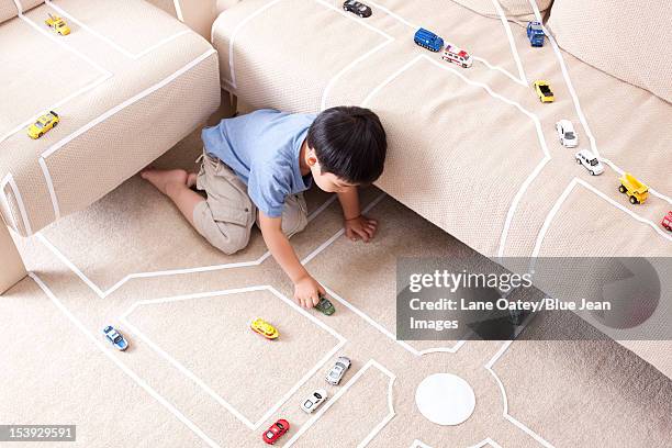 boy playing toy car at home - single lane road - fotografias e filmes do acervo