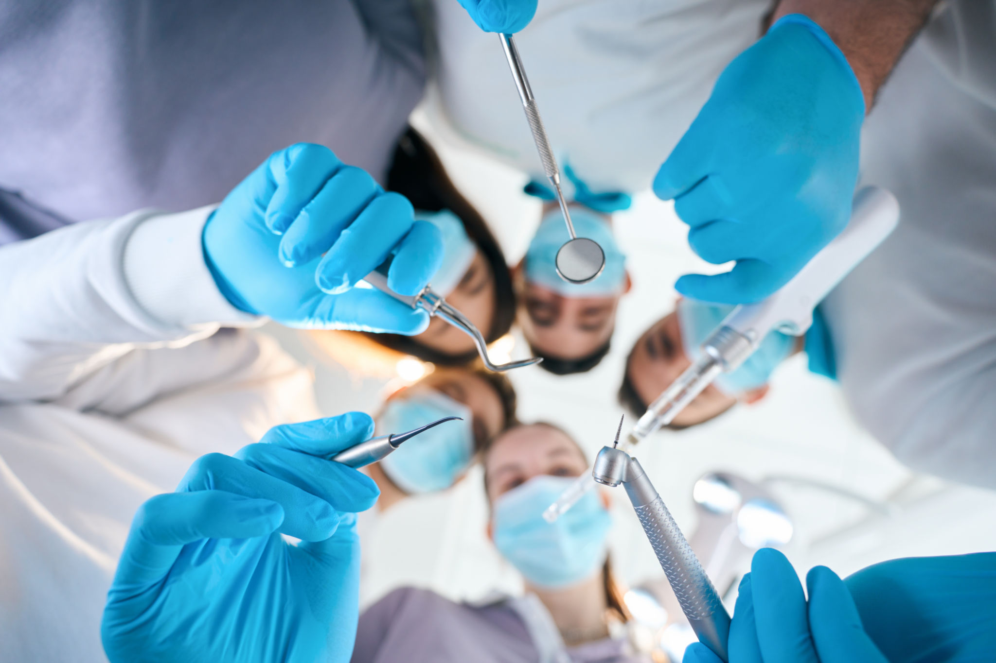 Cinco dentistas con herramientas especiales en sus manos Cinco dentistas con herramientas especiales en sus manos
