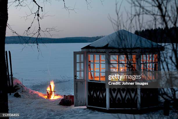 fire in front of gazebo on snowy landscape - brasero photos et images de collection