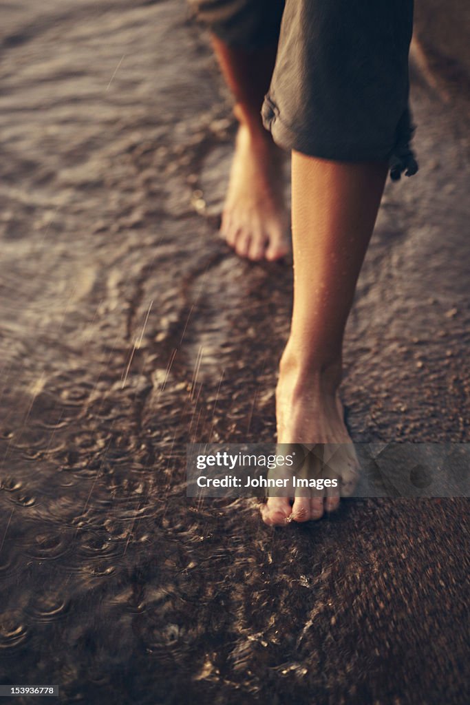 Low section of woman walking on beach