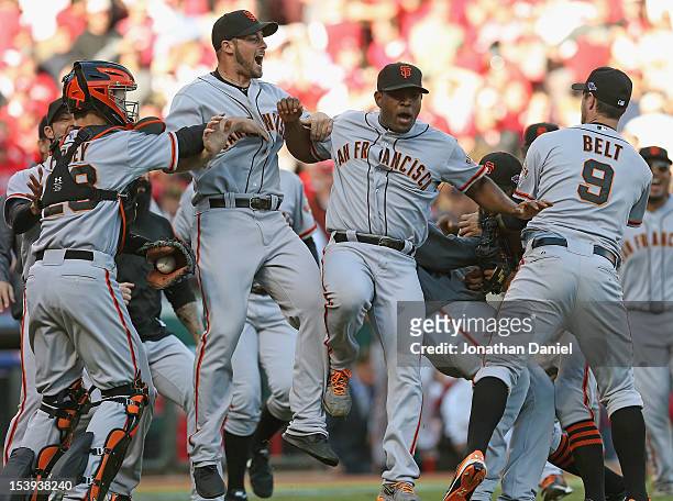 Buster Posey, George Kontos, Santiago Casilla and Brandon Belt of the San Francisco Giants celebrate a win against the Cincinnati Reds in Game Five...