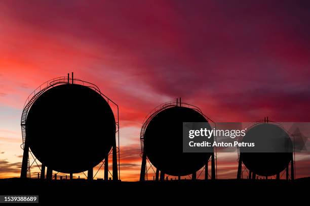 liquefied petroleum gas (lpg) storage tanks at sunset - lagerhaltung stock-fotos und bilder