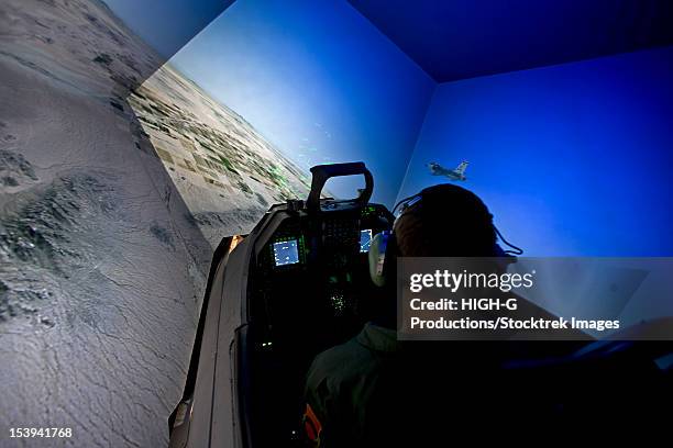 a pilot from the 56th fighter wing in luke air force base, arizona, flies the f-16 simulator. - simulador de vuelo fotografías e imágenes de stock