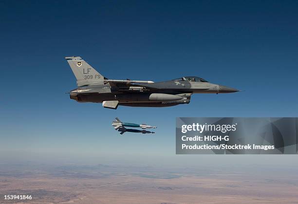 a 56th fighter wing f-16 fighting falcon from luke air force base, arizona, releases two gbu-12 laser guided bombs during a training mission. - bomb drops stock pictures, royalty-free photos & images