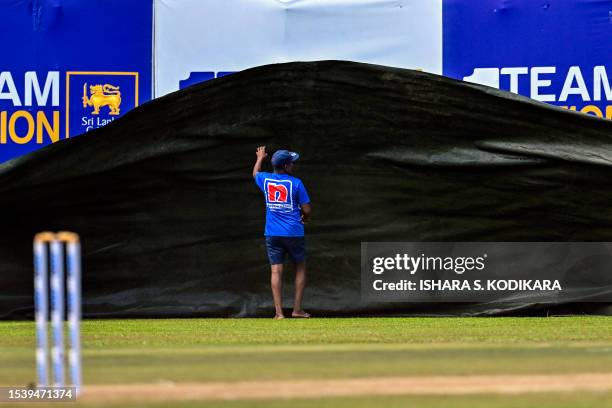 Ground staff uncover the pitch after rain delayed the start of the third day of play of the first cricket Test match between Sri Lanka and Pakistan...