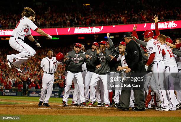 Jayson Werth of the Washington Nationals celebrates with his teammates as he jumps on home plate to score on his solo game-winning walk-off home run...